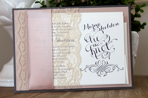 Invitation 1526: This invite has multiple layers and a unique pocket.  A lace and ribbon combination is wrapped around  charcoal and blush paper to create a pocket that will hold your invite card and reply card.