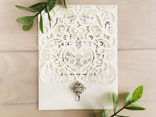 Invitation lc91: Ivory Shimmer, Brooch/Buckle A8 - This is an ivory shimmer pocket style laser cut wedding invite.  There is an extra rhinestone brooch.