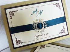 Invitation 935: Gold Pearl, Chocolate Smooth, Cream Smooth, Aqualine 2, Nuncio, Teal Ribbon, Brooch/Buckle R