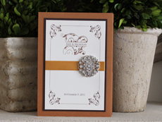 Invitation 938: Cognac, Chocolate Smooth, Cream Smooth, Trajan Pro, Nuncio, Gold Ribbon, Brooch/Buckle X