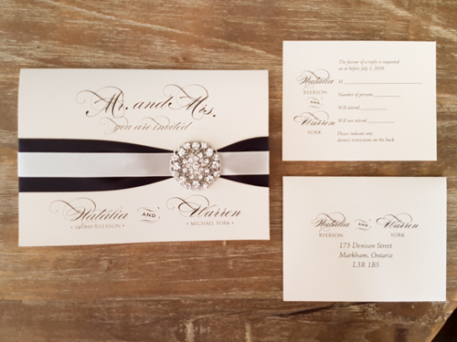 Invitation 1685: White Gold, White Gold, Deep Charcoal Ribbon, Antique Ribbon, Brooch/Buckle X - This is a full flap white gold pearl pocket folder wedding invite.  There is two ribbon stripes and brooch on the cover.