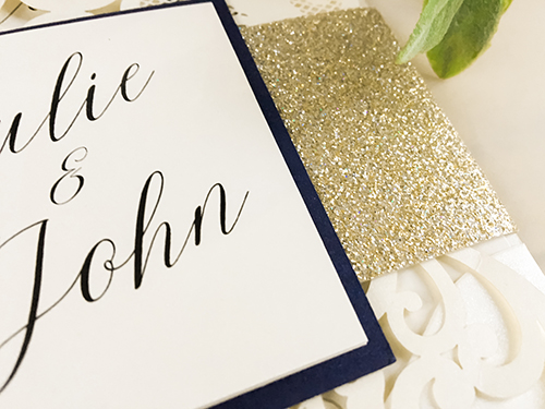 Invitation lc25: This is a pocket style laser cut wedding invitation in the ivory shimmer color.  There is a champagne glitter band with a white gold backing on the cover tag.
