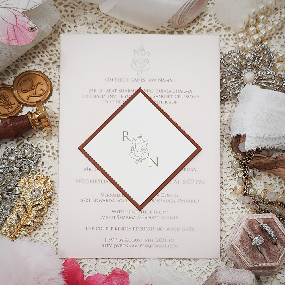 Invitation 8109: White Gold, Rose Gold Mirror, Cream Smooth - Invite on white gold with vellum wrap and diamond layered tag with Ganesh monogram