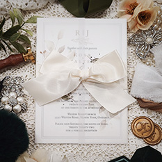 Invitation 3216: White Gold, Antique Ribbon - Single card invitation on white gold with a clear vellum wrap and antique bow.