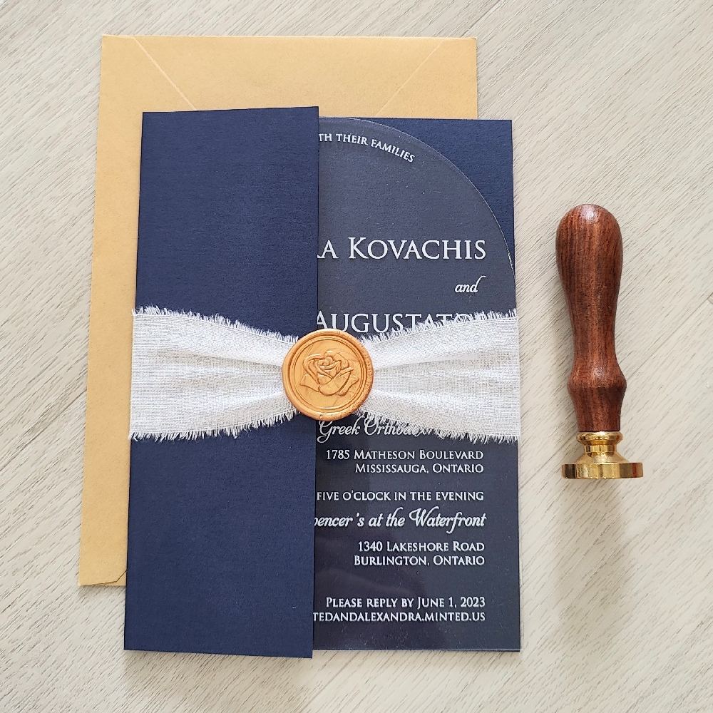 This is a full arch clear acrylic wedding invite contained in a navy pearl half gate folder pocket.  There is a white linen ribbon and gold rose wax seal embellishment around the folder.  This is paired with a metallic gold envelope.  The main layout is printed in a UV white ink.
This wedding took place at the Spencer\'s at the Waterfront in Burlington, Ontario.
Spencer’s at the Waterfront in Burlington, Ontario is one of the most romantic and scenic wedding venues in the GTA, offering a perfect blend of modern elegance and stunning lakefront views. Nestled right on the shores of Lake Ontario, this glass-walled venue creates a breathtaking backdrop for both ceremonies and receptions. This is a full arch clear acrylic wedding invite contained in a navy pearl half gate folder pocket.  There is a white linen ribbon and gold rose wax seal embellishment around the folder.  This is paired with a metallic gold envelope.  The main layout is printed in a UV white ink.
This wedding took place at the Spencer\'s at the Waterfront in Burlington, Ontario.
Spencer’s at the Waterfront in Burlington, Ontario is one of the most romantic and scenic wedding venues in the GTA, offering a perfect blend of modern elegance and stunning lakefront views. Nestled right on the shores of Lake Ontario, this glass-walled venue creates a breathtaking backdrop for both ceremonies and receptions.