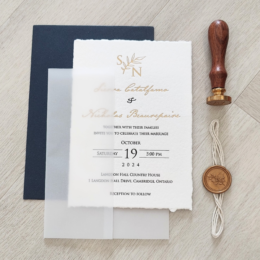 This is a luxurious deckle edge letterpress wedding invitation printed on a 450 gsm white cotton paper with gold foil pressed stamp used for the names and monogram on the layout.  There  is a full vellum wrap enclosure along with a white string and gold branch wax seal embellishment.  The invites are paired with a glittering navy envelope.
This wedding took place at the Langdon Hall Country House in Cambridge, Ontario.
Langdon Hall Country House in Cambridge, Ontario, is one of Canada’s most prestigious and romantic wedding venues. This Relais & Châteaux property combines timeless elegance with a serene countryside setting, making it perfect for couples who want a luxurious yet intimate wedding experience. The historic mansion is surrounded by lush gardens, woodlands, and lawns — ideal for outdoor ceremonies and stunning wedding photography. Inside, Langdon Hall offers beautifully appointed event spaces with classic décor, fireplaces, and refined charm.
Couples can choose from a variety of wedding packages that include exquisite cuisine crafted by the award-winning culinary team, led by Chef Jason Bangerter. The menu focuses on seasonal, locally sourced ingredients, many grown right on the property’s gardens. Guests can also enjoy luxury accommodations in the elegant guest rooms and suites, creating a full weekend retreat atmosphere. Whether hosting a small elopement or an elaborate celebration, Langdon Hall provides exceptional service, fine dining, and an unforgettable romantic setting that feels like a private countryside escape just an hour from Toronto. This is a luxurious deckle edge letterpress wedding invitation printed on a 450 gsm white cotton paper with gold foil pressed stamp used for the names and monogram on the layout.  There  is a full vellum wrap enclosure along with a white string and gold branch wax seal embellishment.  The invites are paired with a glittering navy envelope.
This wedding took place at the Langdon Hall Country House in Cambridge, Ontario.
Langdon Hall Country House in Cambridge, Ontario, is one of Canada’s most prestigious and romantic wedding venues. This Relais & Châteaux property combines timeless elegance with a serene countryside setting, making it perfect for couples who want a luxurious yet intimate wedding experience. The historic mansion is surrounded by lush gardens, woodlands, and lawns — ideal for outdoor ceremonies and stunning wedding photography. Inside, Langdon Hall offers beautifully appointed event spaces with classic décor, fireplaces, and refined charm.
Couples can choose from a variety of wedding packages that include exquisite cuisine crafted by the award-winning culinary team, led by Chef Jason Bangerter. The menu focuses on seasonal, locally sourced ingredients, many grown right on the property’s gardens. Guests can also enjoy luxury accommodations in the elegant guest rooms and suites, creating a full weekend retreat atmosphere. Whether hosting a small elopement or an elaborate celebration, Langdon Hall provides exceptional service, fine dining, and an unforgettable romantic setting that feels like a private countryside escape just an hour from Toronto.
