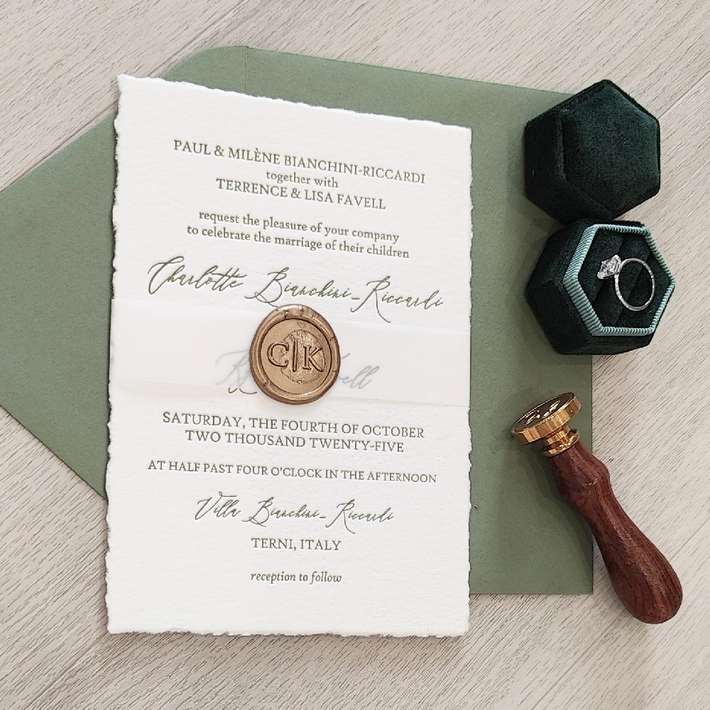 This is a deckled edge letterpress wedding invitation with a thin vellum band and gold custom wax seal.  It is paired with a mid green envelope.
