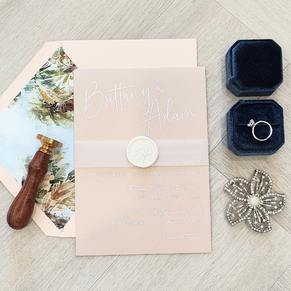 Single card wedding invite on blush paper with a vellum band and white wax seal.  Paired with a blush envelope with designer envelope liner.