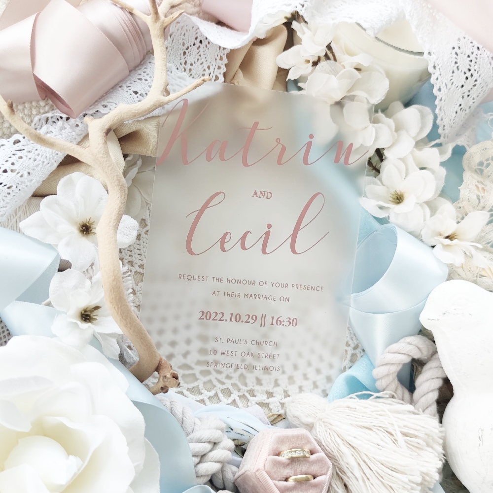 This frosted acrylic wedding invitation with rose gold print has a simple high end sophisticated feel to it. You can add florals a monogram or any other symbol to customize.