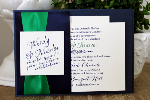 Invitation 1502: This is a navy single pocket invite where the navy pearl paper is folded on the right side to create a pocket which holds the invitation wording card.  A thick emerald ribbon and two navy ribbons are wrapped around the pocket flap.