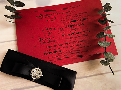 Invitation 1626: Red Lacquer, Red Lacquer, Black Ribbon, Black Ribbon, Brooch/Buckle A8 - This is a landscape orientation wedding invite on a red lacquer paper with a black ribbon and brooch no the right.