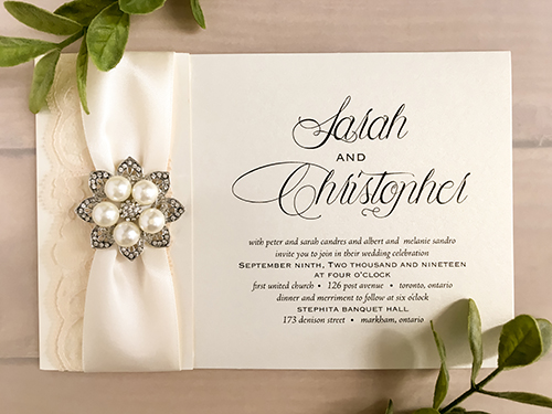 Invitation 2125: White Gold, Antique Ribbon, Cream Lace, Brooch/Buckle T - This is a folded over white gold pearl wedding invite.  There is an antique ribbon, cream lace and brooch on the design.