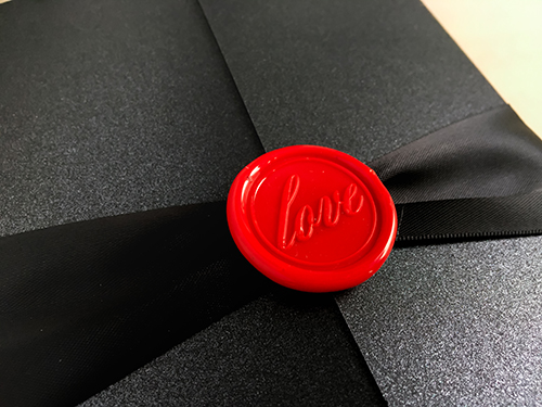 Invitation 2256: Black Pearl, Red Wax, Black Ribbon - This is a gate fold invitation in black pearl paper with a black ribbon and red wax seal.