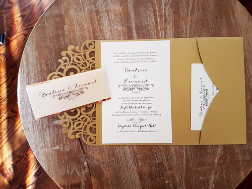Invitation lc112: Metallic Gold, Gold Mirror, Cream Smooth - This is a metallic gold laser cut wedding invitation with a vellum belly band that has a gold mirror backing.