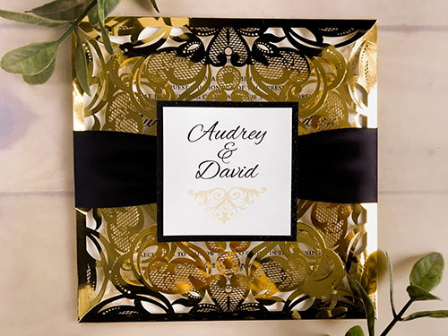 Invitation lc114: Mirror Gold, Black Glitter, Cream Smooth, Black Ribbon - This is a shiny gold mirror laser cut four flap wedding invitation design.  There is a black ribbon with a black glitter cover tag.