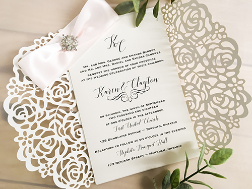 Invitation lc116: This is a silver mirror gate fold laser cut wedding invite.  The flaps have a rose design pattern.  There is a petal pink ribbon and brooch tied around.