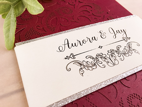Invitation lc118: Burgundy Shimmer, Silver Glitter, Cream Smooth - This is a burgundy shimmer laser cut wedding invitation.  There is a silver glitter layered belly band wrapped around the card.