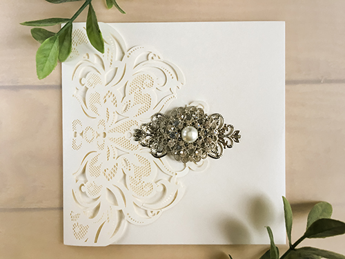 Invitation lc119: Ivory Shimmer, Cream Smooth, Brooch/Buckle A6, Metal Filigree F4 - Silver - This is a damask style ivory shimmer laser cut wedding card.  There is a combo brooch on the cover flap.
