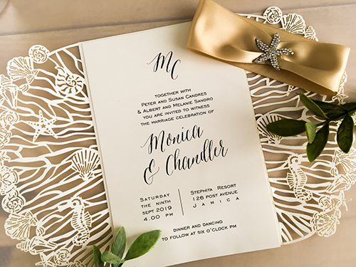 Invitation lc132: Ivory Shimmer, Cream Smooth, Champagne Ribbon, Brooch/Buckle A10 - This is an ivory shimmer laser cut wedding invite that is a gate fold design.  There is a champagne ribbon and brooch wrapped around.