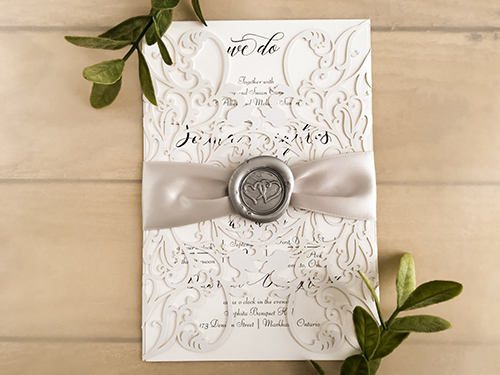 Invitation lc133: White Shimmer, White Smooth, Silver Wax, Silver Ribbon - This is a white shimmer gate fold laser cut wedding invite.  There is a silver ribbon and silver wax seal look.