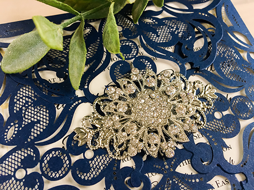 Invitation lc21: Glittering Navy, Cream Smooth, Brooch/Buckle A11, Metal Filigree F4 - Silver - This is a four flap glittering navy laser cut wedding card.  There is a combo brooch on the flap.