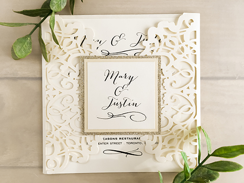 Invitation lc33: Ivory Shimmer, Buttermilk Pearl, Cream Smooth - This is a gate fold laser cut wedding card in ivory shimmer.  There is 2 layers on the cover tag in buttermilk pearl and champagne glitter.