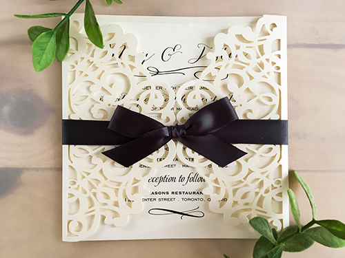 Invitation lc44: Ivory Shimmer, Cream Smooth, Deep Charcoal Ribbon - This is an ivory shimmer laser cut wedding invite with a deep charcoal bow tied around the card.