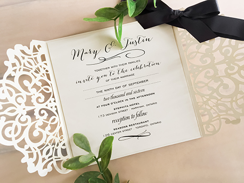 Invitation lc44: Ivory Shimmer, Cream Smooth, Deep Charcoal Ribbon - This is an ivory shimmer laser cut wedding invite with a deep charcoal bow tied around the card.