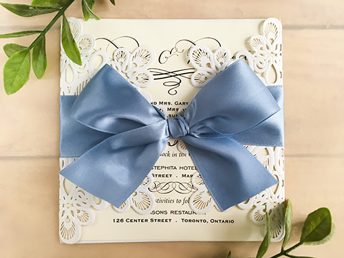 Invitation lc50: Glittering White, Cream Smooth, Blue Mist Ribbon - This is a glittering white laser cut wedding invitation.  There is a large blue mist bow tied around the invitation.