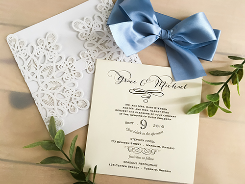 Invitation lc50: Glittering White, Cream Smooth, Blue Mist Ribbon - This is a glittering white laser cut wedding invitation.  There is a large blue mist bow tied around the invitation.