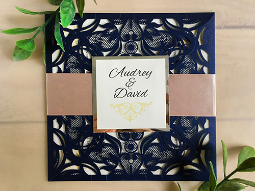 Invitation lc53: This is a four flap laser cut wedding invitation in the glittering navy color.  The deep blush ribbon wraps around the card with the silver mirror cover tag.