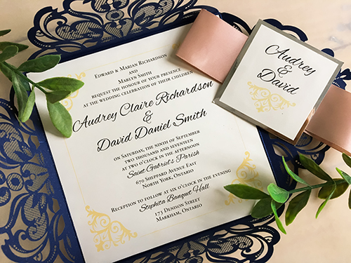 Invitation lc53: This is a four flap laser cut wedding invitation in the glittering navy color.  The deep blush ribbon wraps around the card with the silver mirror cover tag.