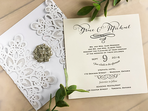 Invitation lc55: Glittering White, Cream Smooth, Brooch/Buckle A17 - This is a glittering white laser cut wedding invitation.  There is a rhinestone brooch glued to the middle.