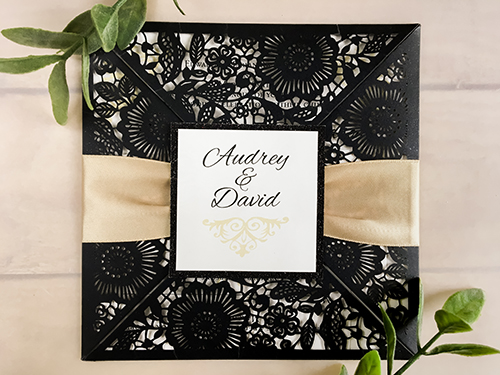 Invitation lc65: Glittering Black, Black Glitter, Cream Smooth, Champagne Ribbon - This is a glittering black four flap laser cut wedding invite.  There is a champagne ribbon tied around with a black glitter cover tag.