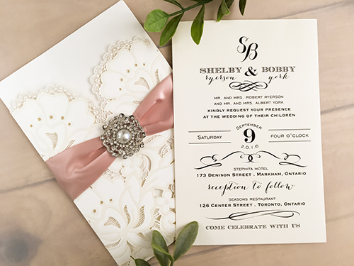 Invitation lc77: Ivory Shimmer, Blush Ribbon, Brooch/Buckle Q - This is an ivory shimmer pocket style laser cut wedding invite.  There is a blush ribbon and pearl brooch.