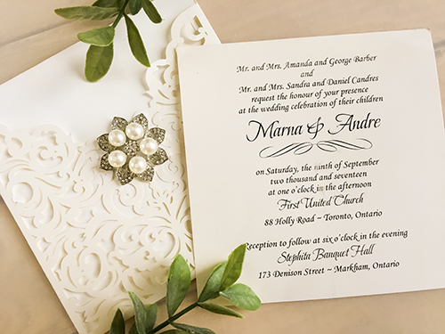 Invitation lc79: Ivory Shimmer, Brooch/Buckle T - This is an ivory shimmer pocket style laser cut wedding invite.  There is a five pearl rhinestone brooch on the front.