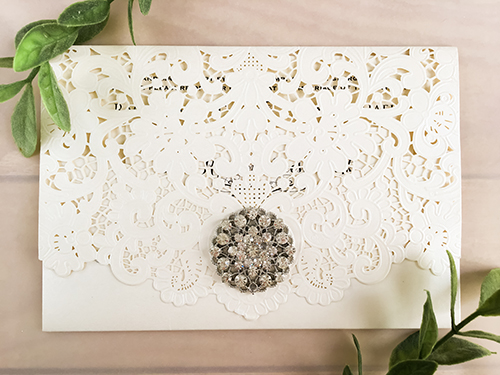 Invitation lc89: Ivory Shimmer, Brooch/Buckle A6 - This is an ivory shimmer pocket style laser cut wedding invite.  There is a rhinestone brooch on the flap.