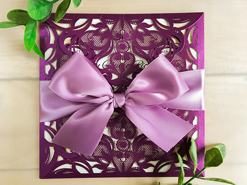 Invitation lc8: Square 4 flap laser cut invitation with a big 1.5 inch billowing bow, hand tied with love. Shown here in purple shimmer, accepted with a complimentary purple bow (grape colour)