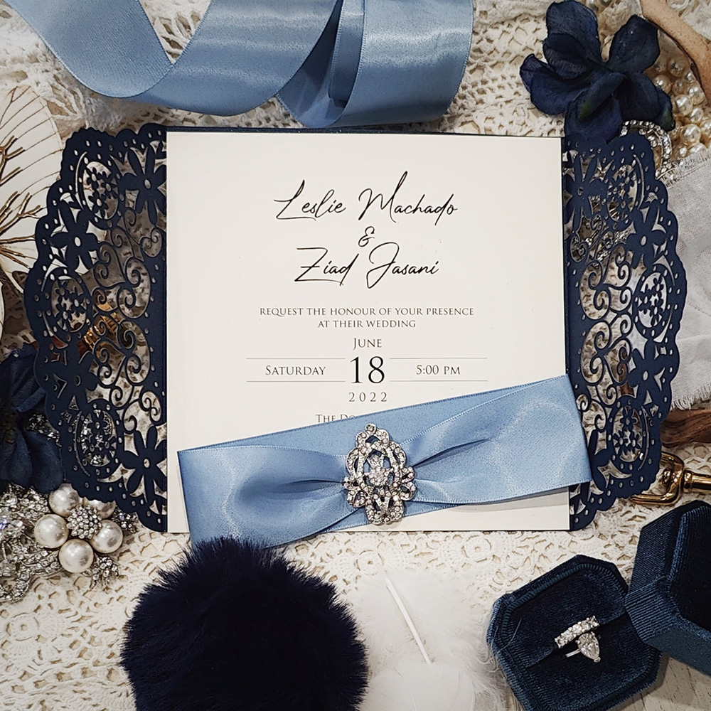 Invitation 8005: Glittering Navy, Cream Smooth, Blue Mist Ribbon, Brooch/Buckle A10 - navy lasercut with blue mist ribbon and brooch