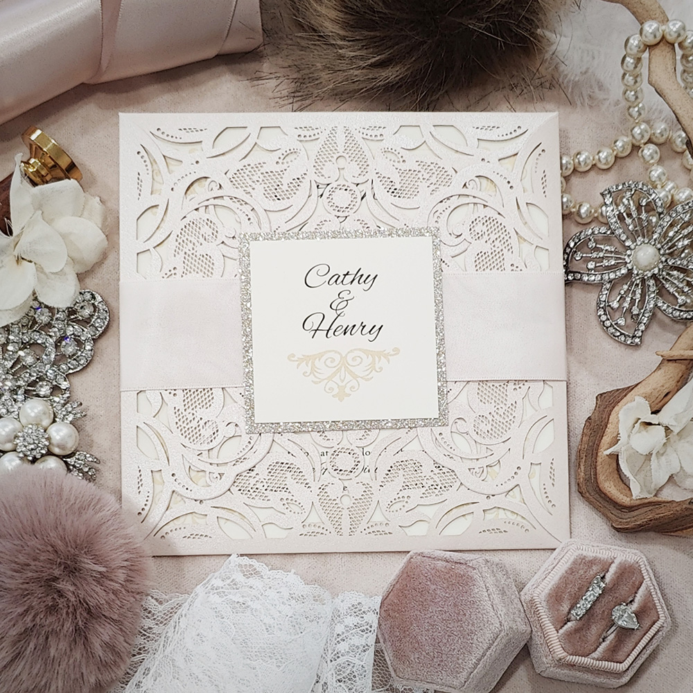 Invitation 8030: Ivory Shimmer, Champagne Glitter, Cream Smooth, Petal Pink Ribbon - ivory lasercut envelopement with ribbon and layered tag