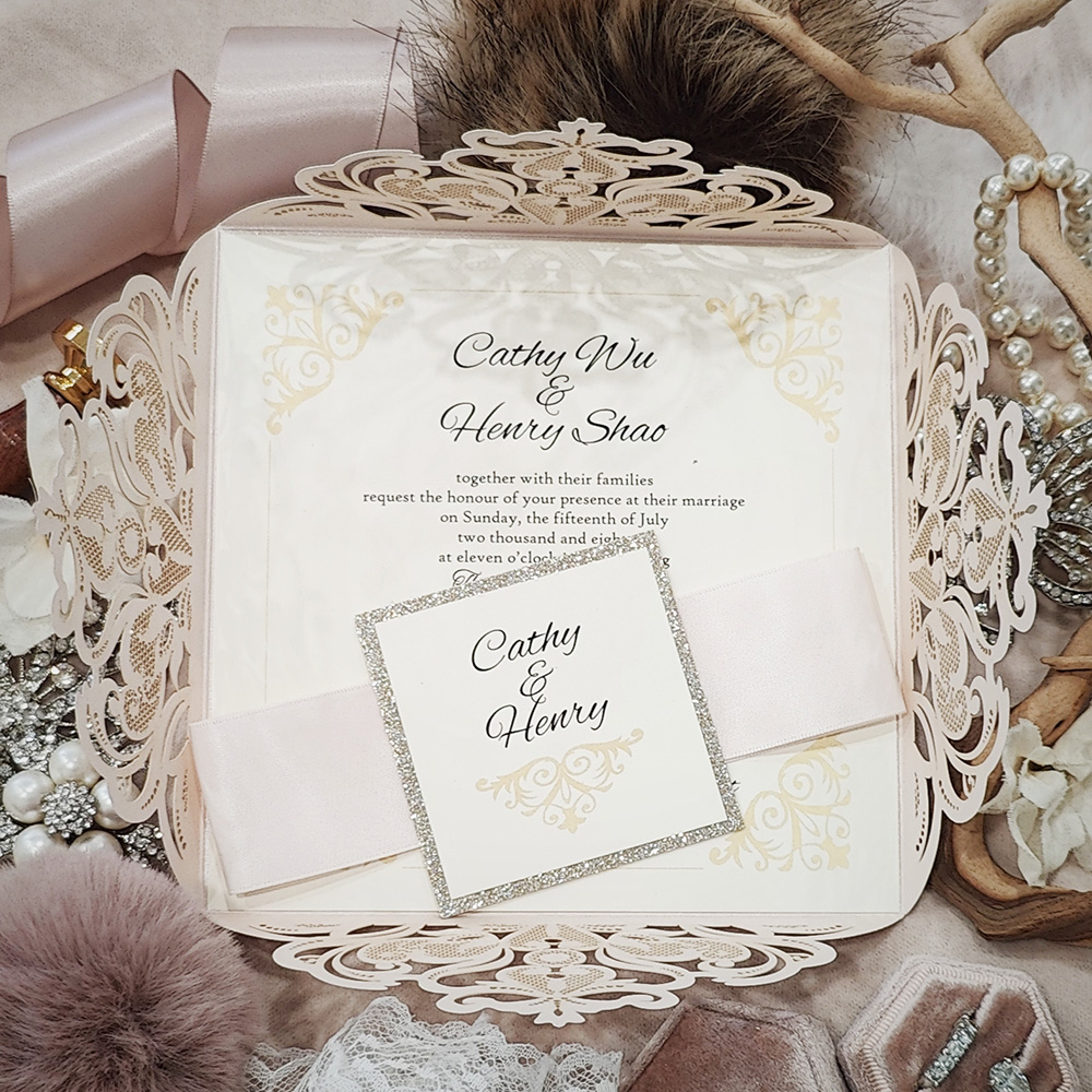 Invitation 8030: Ivory Shimmer, Champagne Glitter, Cream Smooth, Petal Pink Ribbon - ivory lasercut envelopement with ribbon and layered tag