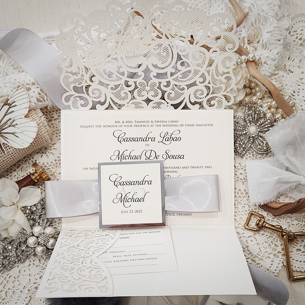 Invitation 8039: Ivory Shimmer, Silver Mirror, Cream Smooth, Silver Ribbon - Ivory pocketfold lasercut with ribbon and layered tag