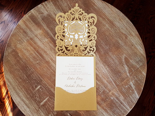 Invitation mb27: Metallic Gold, Gold Mirror, Cream Smooth - This is a metallic gold laser cut pocket invitation with a rhinestone jewel on the cover flap.  There is also an extra layered cover tag on the cover.