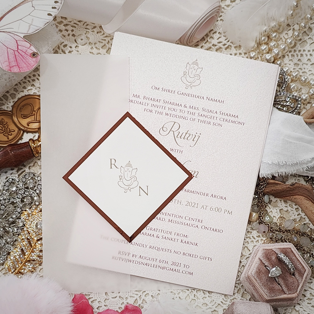 Invitation 8109: White Gold, Rose Gold Mirror, Cream Smooth - Invite on white gold with vellum wrap and diamond layered tag with Ganesh monogram