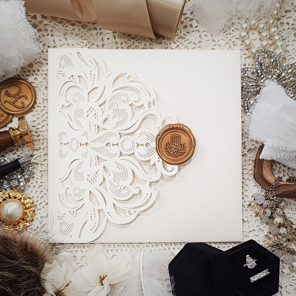 Invitation 8114: Ivory Shimmer, Cream Smooth, Gold Wax - ivory lasercut pocketfold with Bismillah wax seal and floral design