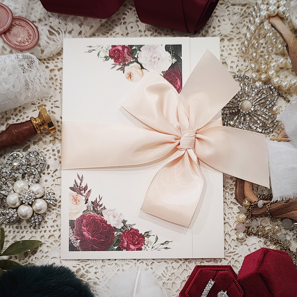 Invitation 3107: Antique Pearl, Blush Ribbon - Pocketfold wedding invitation on an antique pearl paper with a blush bow tied around.