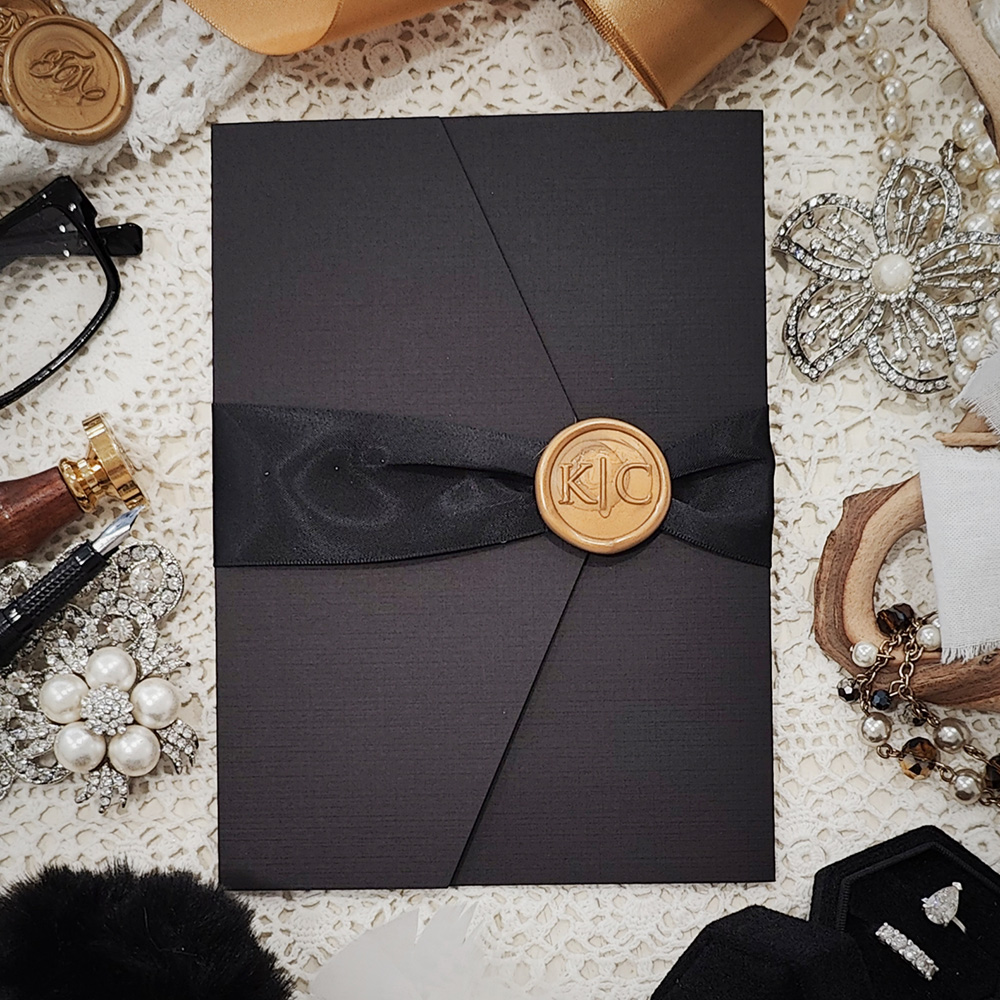 Invitation 3119: Black Linen, Cream Smooth, Gold Wax, Black Ribbon - Pocketfolder wedding invite with a printed insert, black ribbon and gold wax seal on a black folder.
