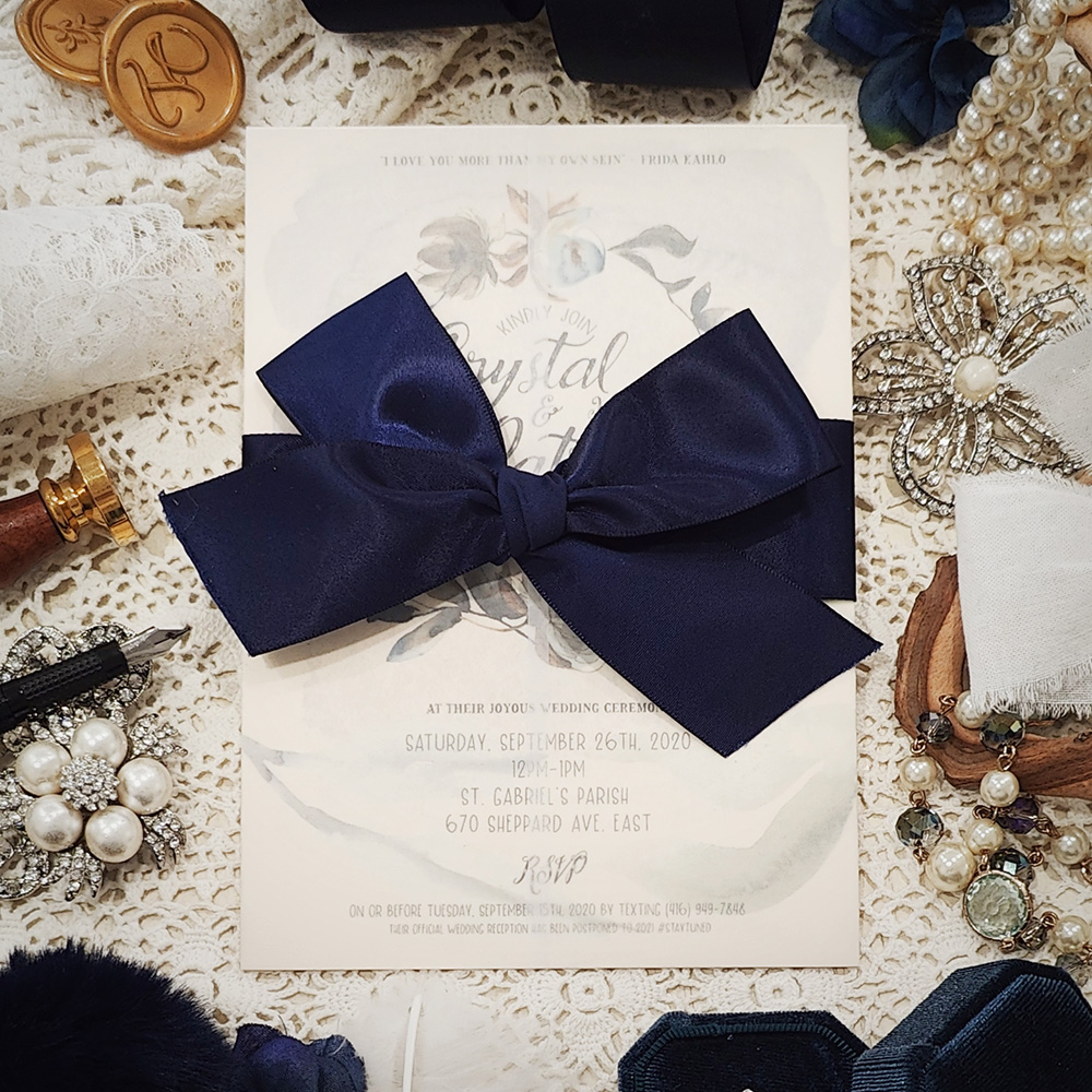 Invitation 3204: White Gold, Navy Ribbon - Single card wedding invite with a clear vellum wrap and big navy bow tied around.